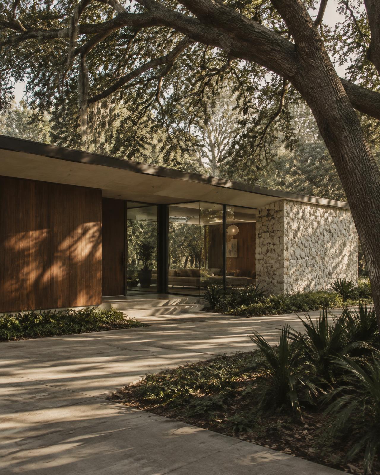 Mid-century modern home with walnut siding beneath live oaks